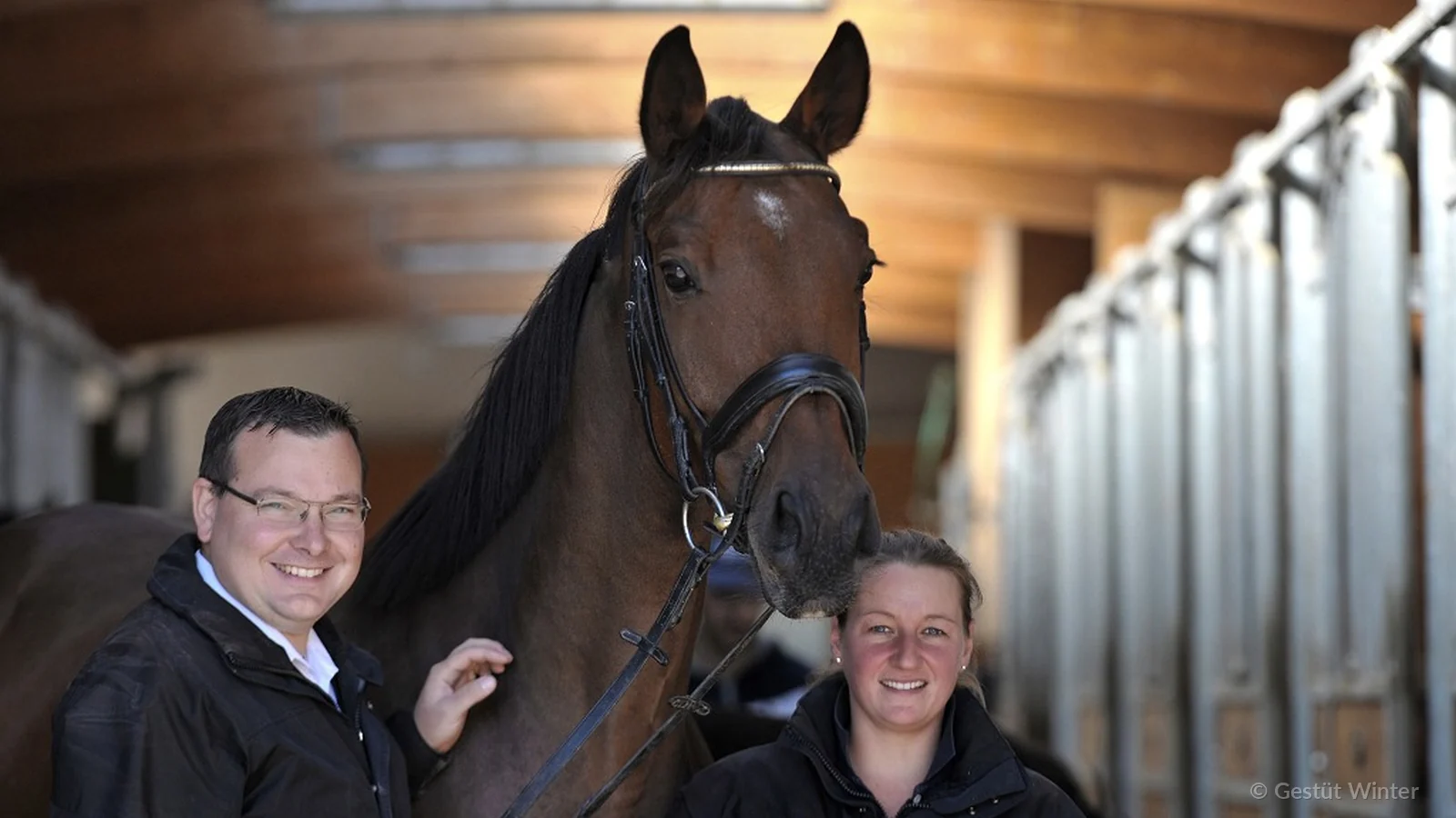 Andreas and Steffi Winter standing beside a bay dressage horse at Gestüt Winter